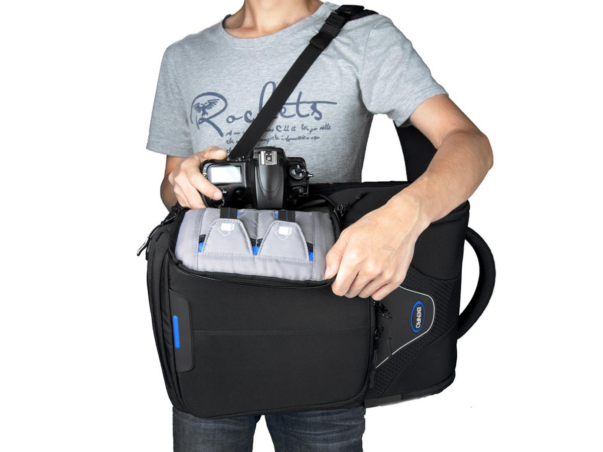 Mochila Benro Beyond B400N con acceso lateral rápido extrayendo cámara DSLR con grip montado
